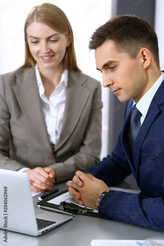 Business people using laptop pc while discussing project in office