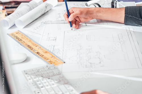 Closeup of human hand drawing blueprint, architect or designer, constructing house plan