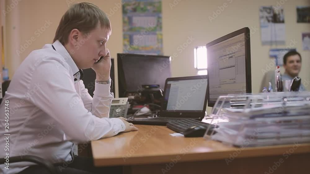 an talking on mobile phone whilst using computer an talking on mobile phone whilst using computer
