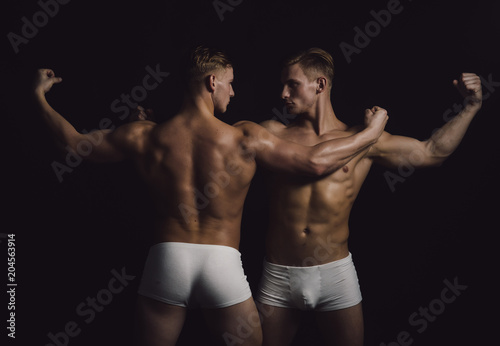 sportsmen with muscular body. sportsmen twins in bodybuilder pose.