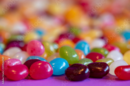 Jellybean candy on purple table receding into blurred colors.