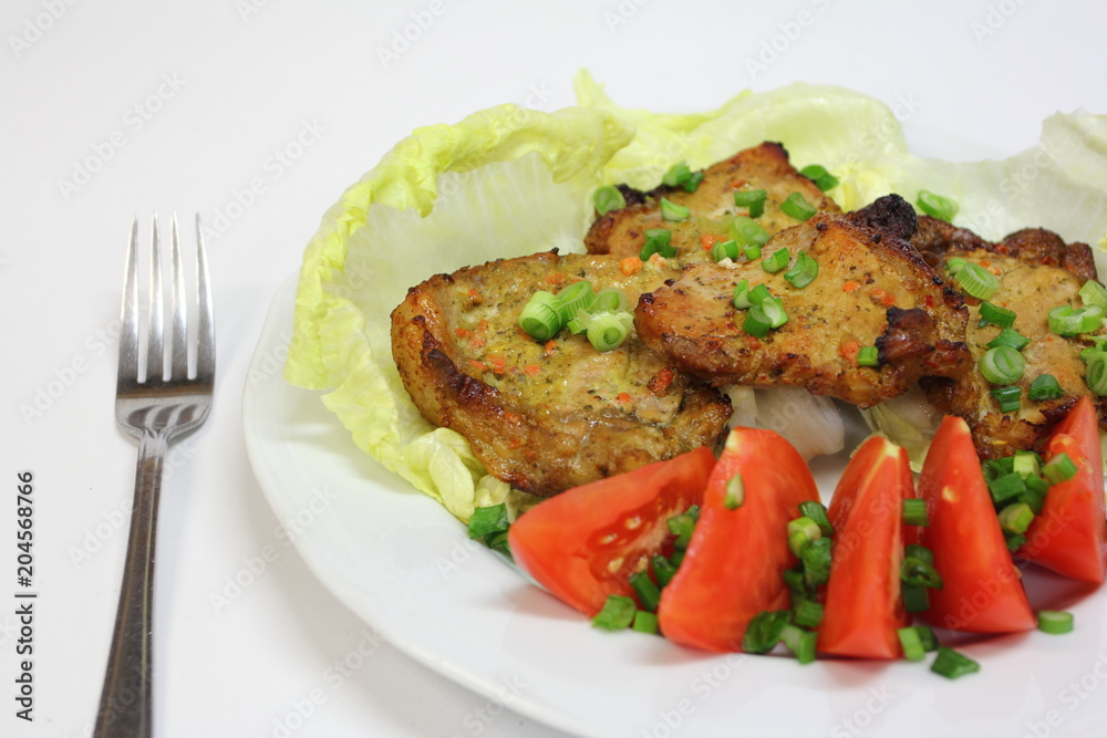 fried pieces of pork chop with lettuce, tomatoes and chives fried pieces of pork chop with lettuce, tomatoes and chives