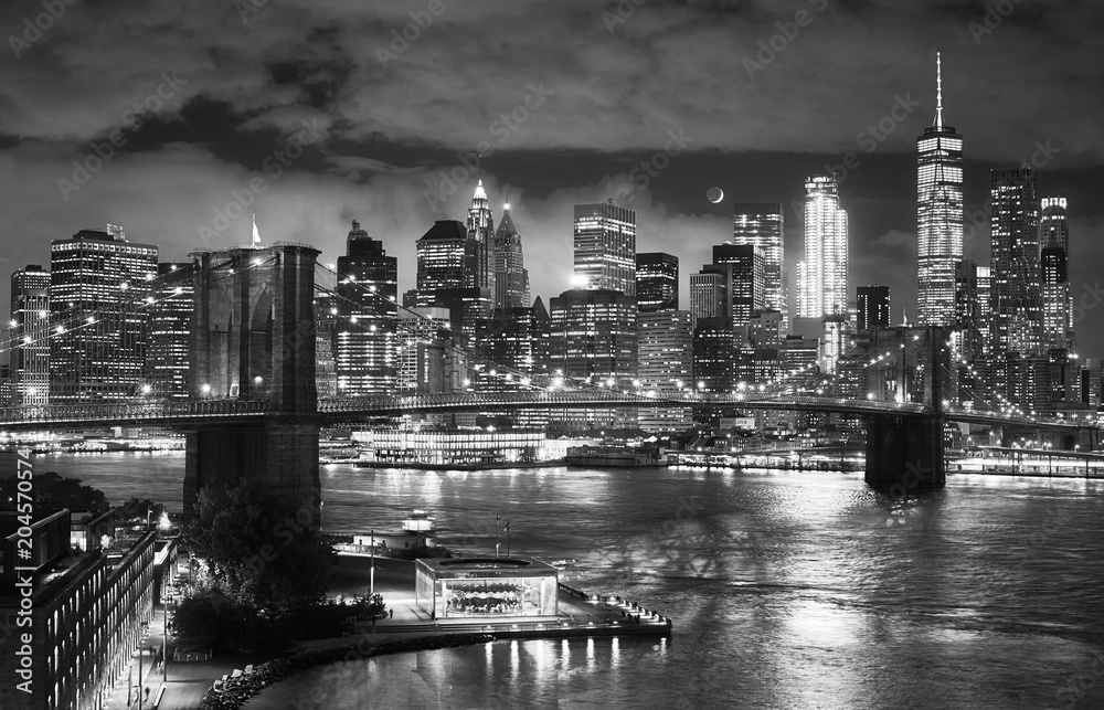 Naklejka premium Czarno-biały obraz Mostu Brooklińskiego i Manhattanu widziany z Dumbo nocą, Nowy Jork, USA.