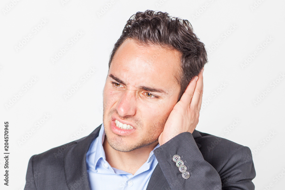 Businessman suffering from ear pain Businessman suffering from ear pain