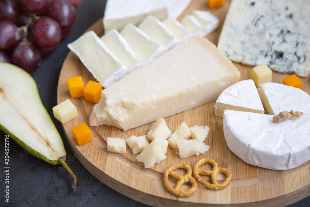 Tasting cheese with fruits, pretzels and walnuts, side view. Food for wine.