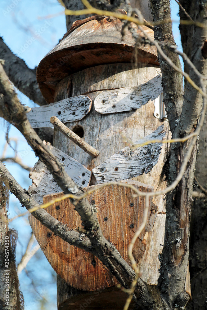 The nesting box, wooden lodge for birds on a tree trunk.