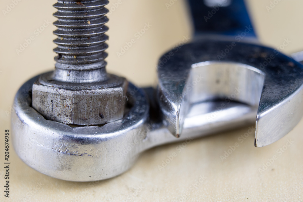 Metric screw and key on a wooden table. Mechanical accessories in the locksmith workshop. Metric screw and key on a wooden table. Mechanical accessories in the locksmith workshop.