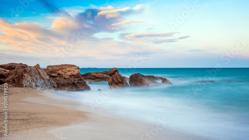 Rocks on a sandy beach in Miami Platja, Catalunya, Spain. Copy space for text photo