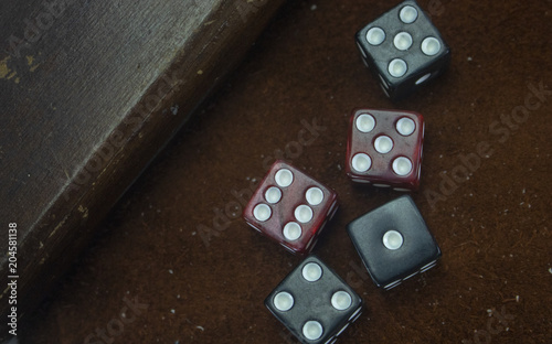 A collection of dice sits on a leather background. 