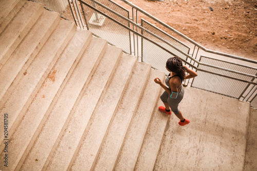 Young african american woman is running up stairs © Nebojsa