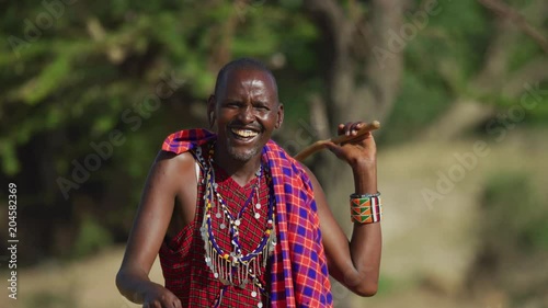 Maasai man laughing and holding a rungu photo