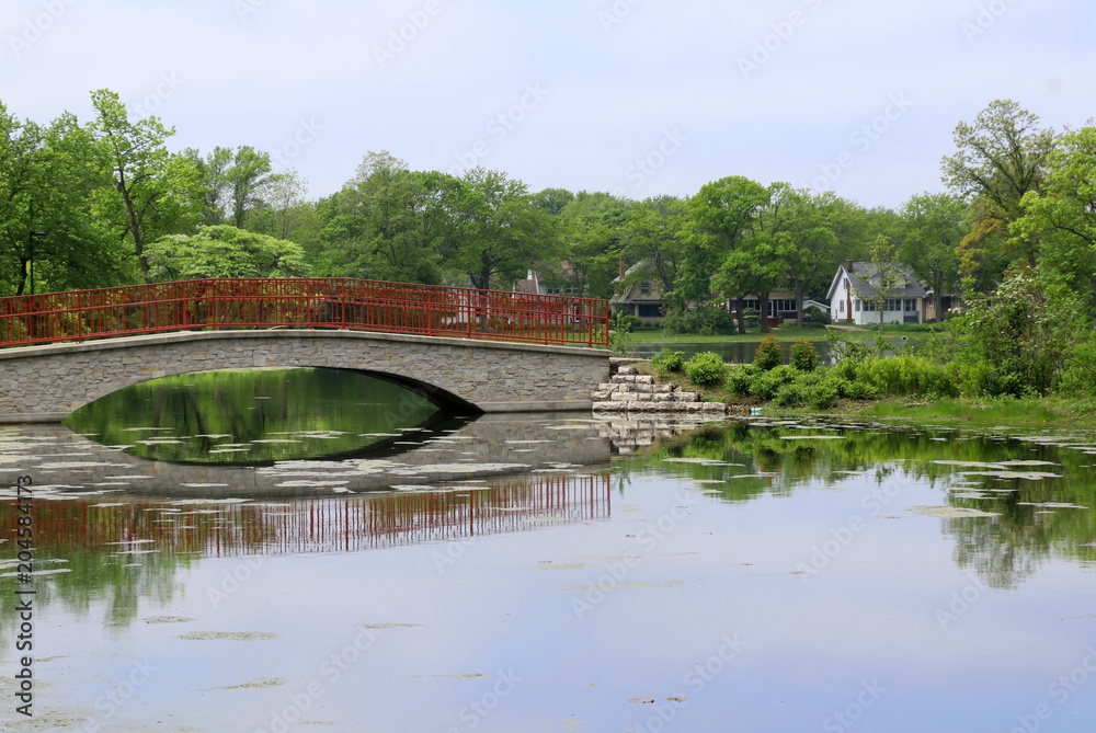 Beautiful summer landscape in a city park.Beautiful summer landscape with a bridge and fresh green color trees and grass around the lake Mendota bay in a Tenney Park, city of Madison, Wisconsin, USA.
