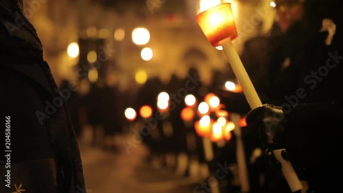 Close up, people hold candles in religious service