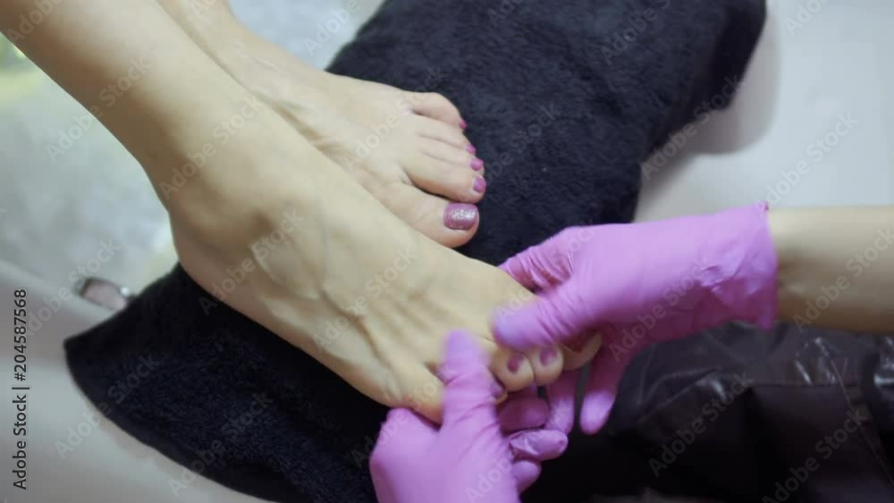 Master massaging steamed skin of feet during the procedure of pedicure Master massaging steamed skin of feet during the procedure of pedicure