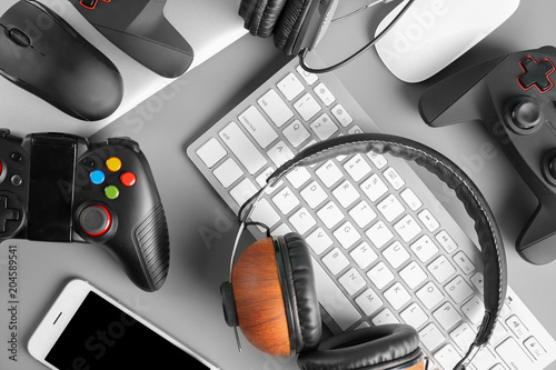 Gamepads, mice, headphones and keyboard on table photo