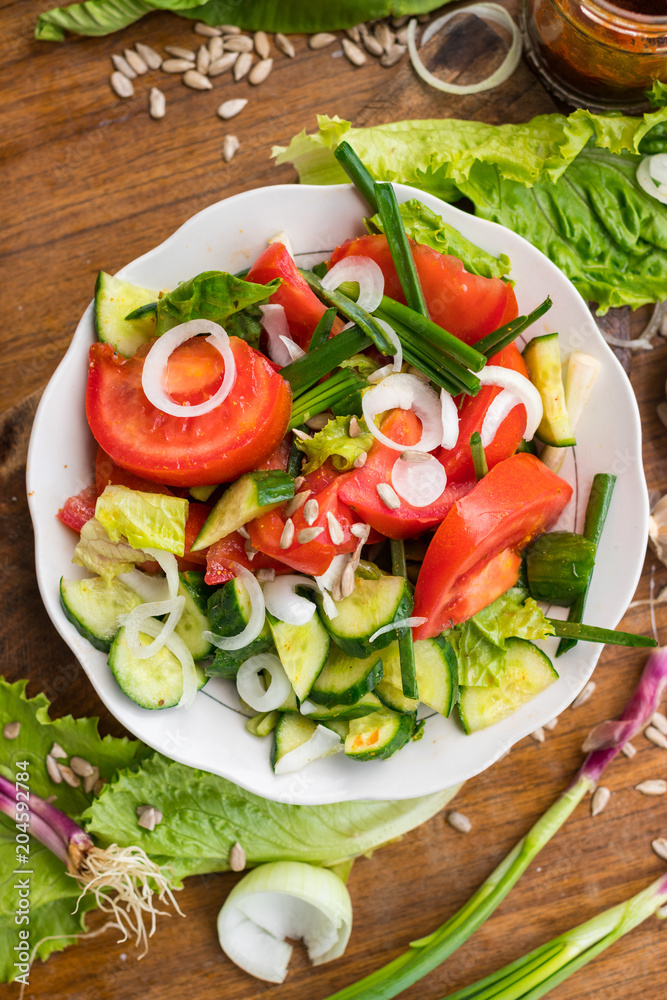 Fresh vegetables Greek salad with tomatoes, cucumbers, onion slices and sprouts. Served with olive oil. Raw vegan vegetarian healthy food