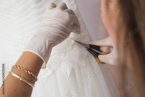Hands works on wedding dress repair