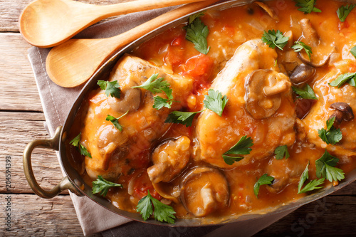 Fotobehang  Chicken chasseur is a classic French dish with mushrooms and tomatoes in smooth sauce close-up