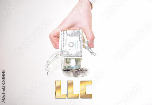 A businessman with a bank of money shows an inscription:LLC