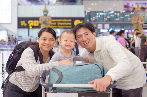 Asian family with cute 18 months / 1 year old toddler baby boy child in airport before boarding at Suvarnabhumi Airport (Bangkok public international airport), Family travel, vacation with kid concept
