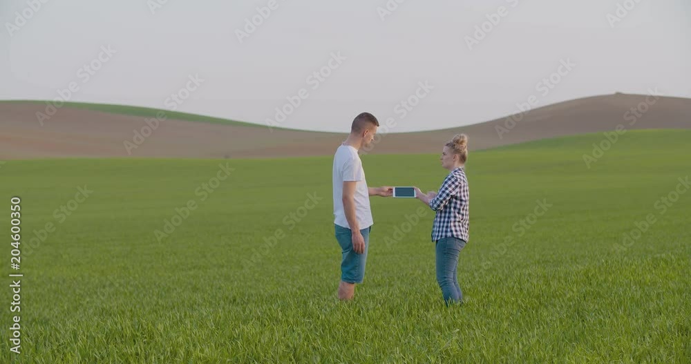 Farmers Discussing Over Digital Tablet In Middle Of Farm Farmers Discussing Over Digital Tablet In Middle Of Farm