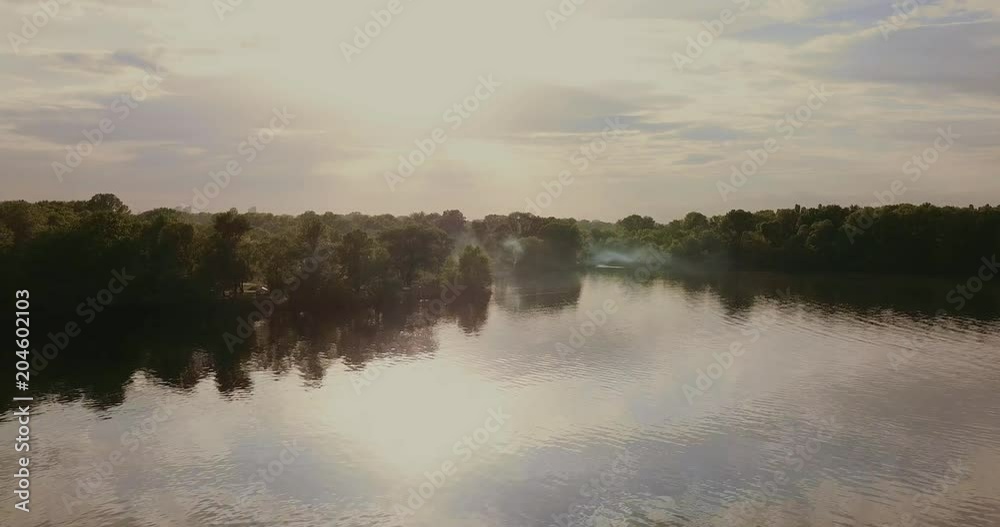 Flight over the river on the beach camping with smoke from cooking. Flight over the river on the beach camping with smoke from cooking.