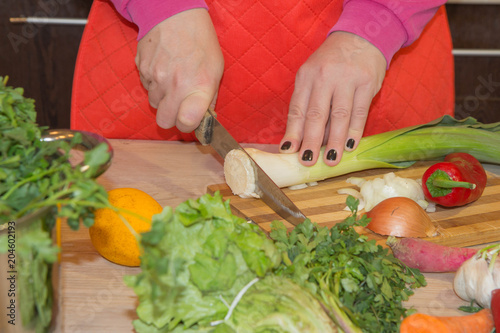 woman hands cutting vegetables on kitchen blackboard. Woman preparing vegetables