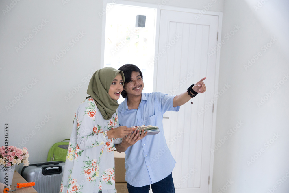 Fototapeta premium muslim couple choosing paint for the wall