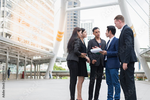 Group of business people standing in the city and discussing ideas for business future. multi culture of business people, African, Caucasian and Asian.