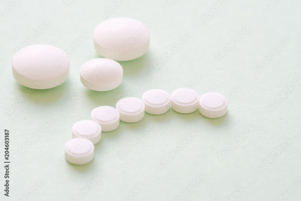 Sad patient face made from white round pills on green Sad patient face made from white round pills on green