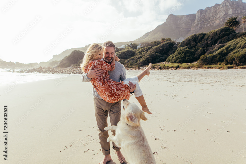 Fototapeta Romantyczna para dojrzałych z psem na plaży