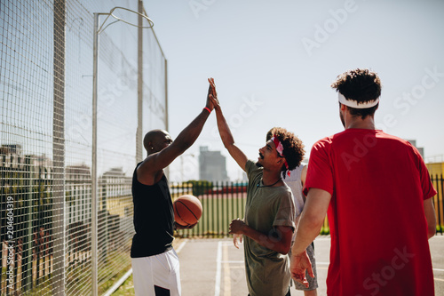 Men playing basketball in basketball court