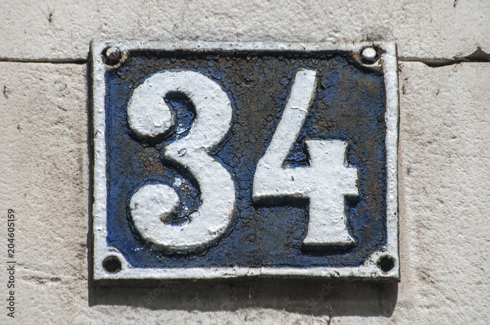 Old retro weathered cast iron plate with number 34 closeup Old retro weathered cast iron plate with number 34 closeup