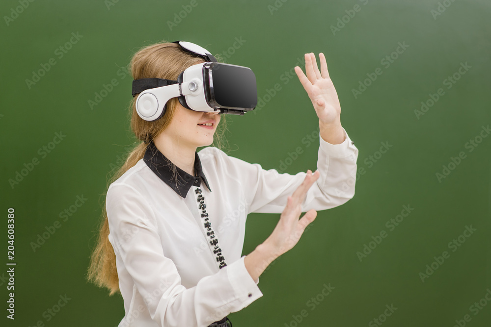 Teen girl using VR headset on the background of a school board Teen girl using VR headset on the background of a school board