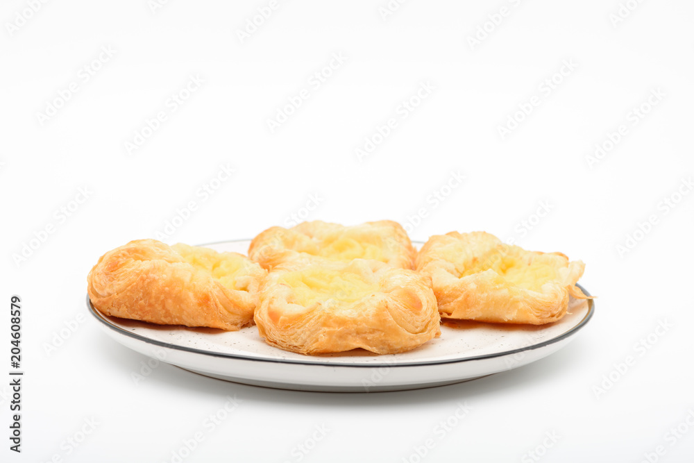 A plate of  of mini danish pastries with lemon cheesecake filling on top, white background.