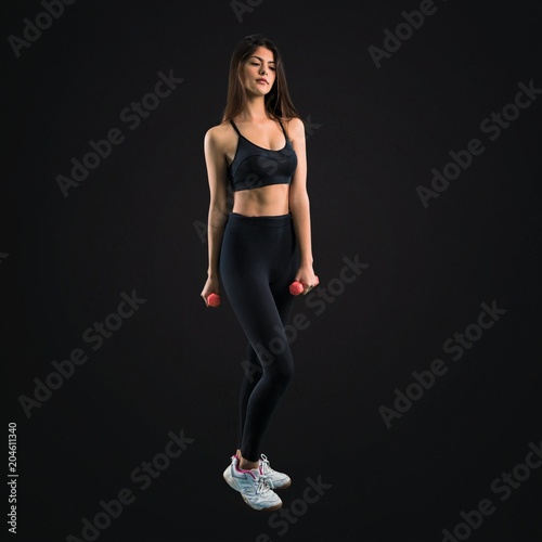 Young sport girl making weightlifting on black background