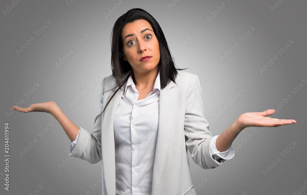 Pretty woman making unimportant gesture on grey background Pretty woman making unimportant gesture on grey background