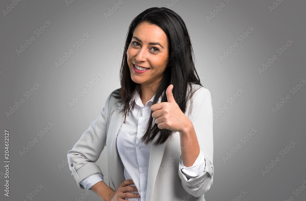 Pretty woman with thumb up on grey background Pretty woman with thumb up on grey background