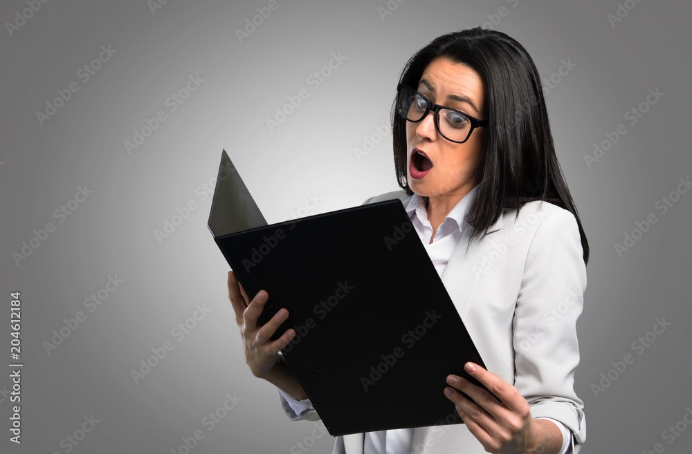 Pretty woman with glasses and holding binder on grey background Pretty woman with glasses and holding binder on grey background