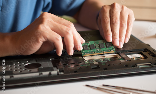 The engineer repairs the laptop (pc, computer) and the motherboard. Installs the equipment (ram)
