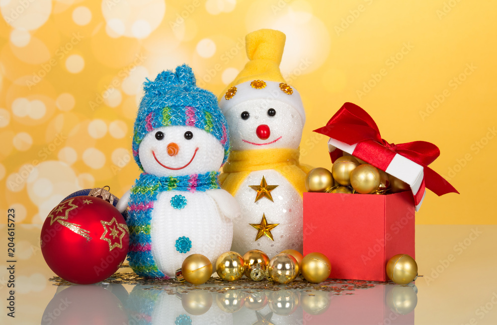 Two little funny snowman, Christmas toys, gifts and surprises, on yellow background