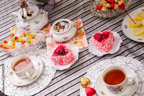 Porcelain cup of tea with lemon and sweets