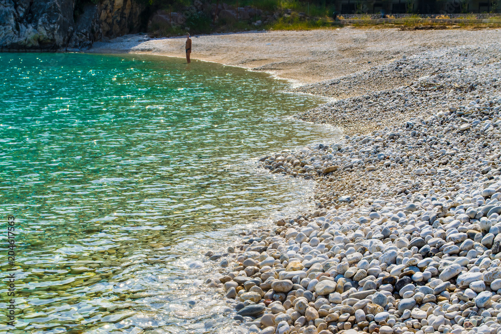Crystal clear turquoise sea waters of a pebble beach. Poros beach in Lefkada ionian island in Greece