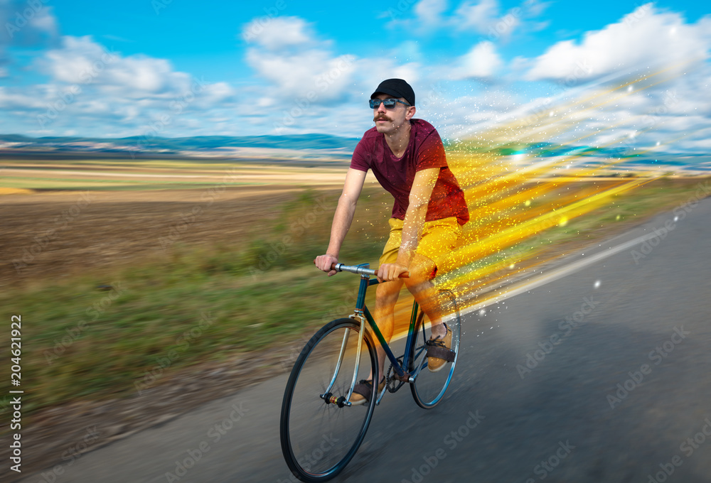 Fototapeta premium Young riding bicycle in fabulous nature with high speed