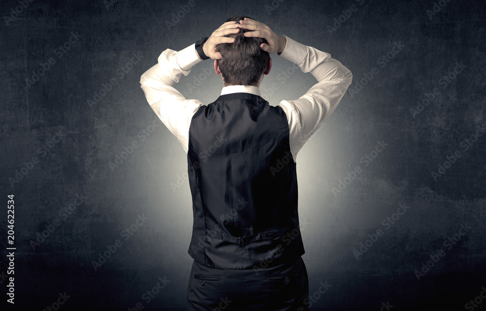 Young businessman standing and thinking alone Young businessman standing and thinking alone