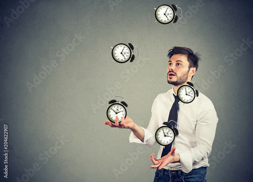 business man juggling his time alarm clocks photo
