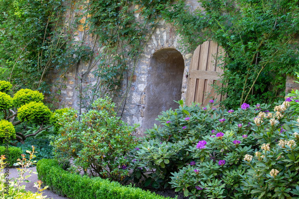 Hidden door in a stony wall in the garden of a old castle 