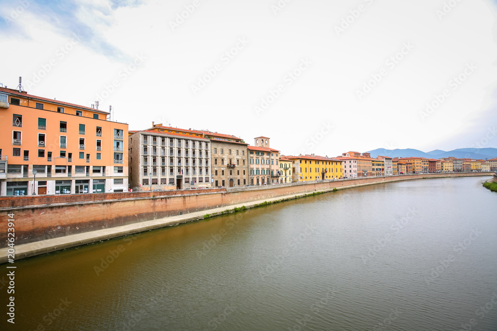 Old residential architecture with river Arno in Pisa, Italy.