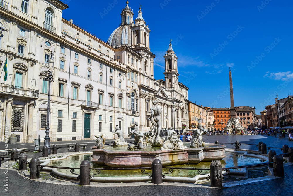Fototapeta premium Fountain of the four Rivers with Egyptian obelisk, in the middle of Piazza Navona in Rome, Italy, with Sant'Agnese in Agone church at the background