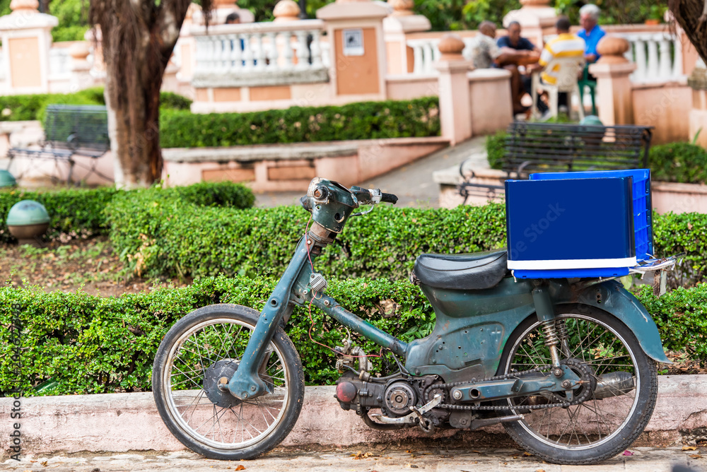 Obraz premium Motorcycle with a blue trunk on a city street, Santo Domingo, Dominican Republic. Close-up.